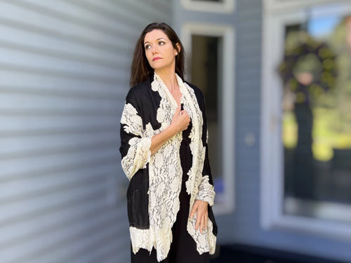 Black and white wool and silk lace scarf by Amoura, showcasing intricate lace pattern and soft, luxurious fabric.